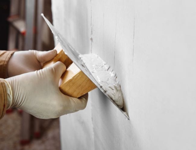 Alisar el gotelé con una pasta alisadora para nivelar la pared